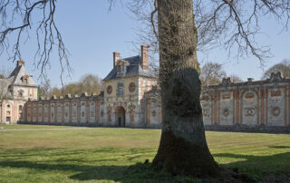 photo de la porte et murs de l'enceinte du château avec un arbre au premier plan